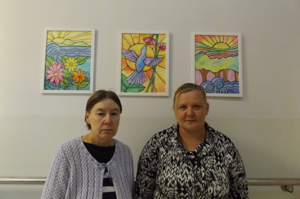 Pani Agnieszka i pani Irena stojące przy swoich obrazach na holu pałacu DPS.